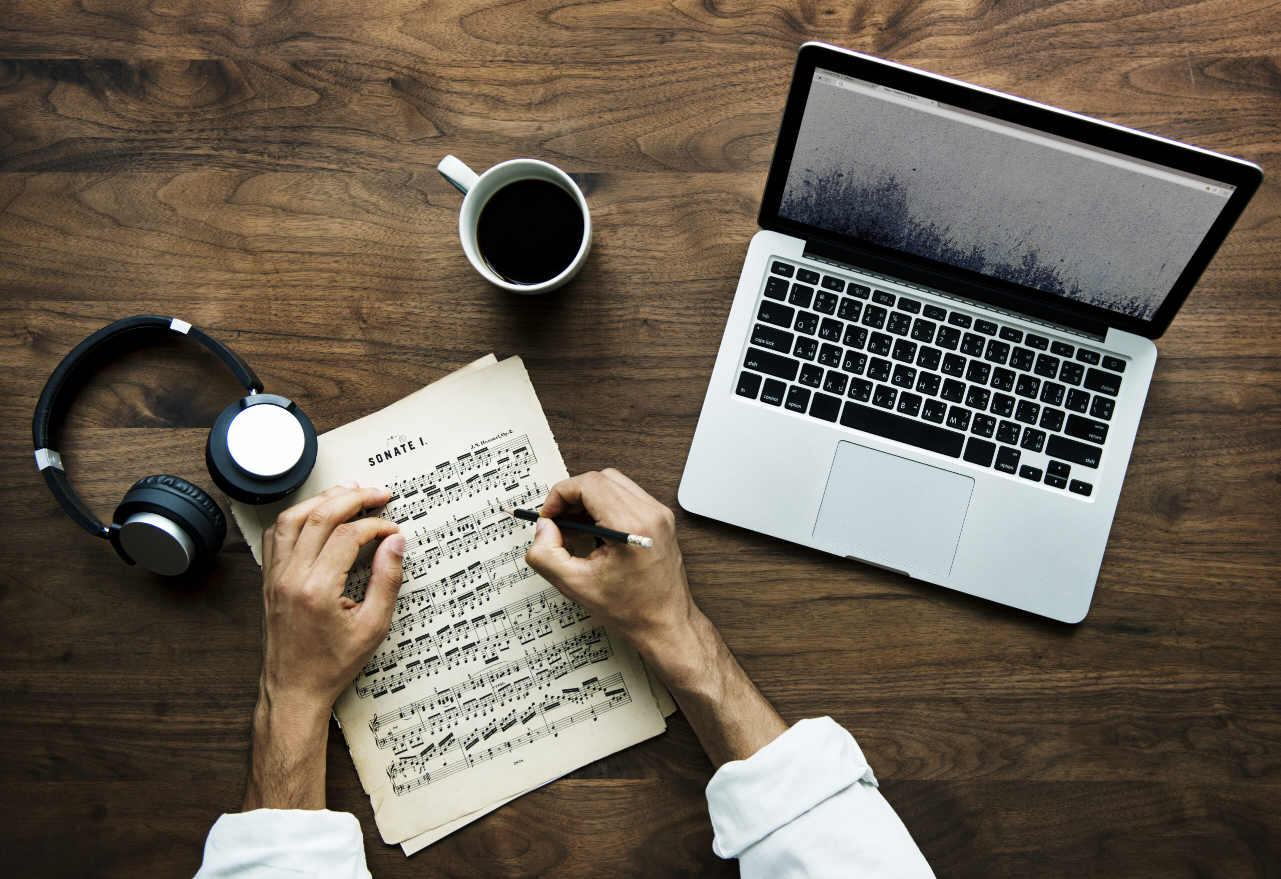 Aerial view of a laptop on a wooden table used for transcription services work setup