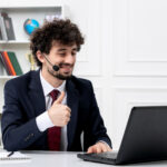 Smiling remote tech support agent in a headset assisting customers from a home office setup.