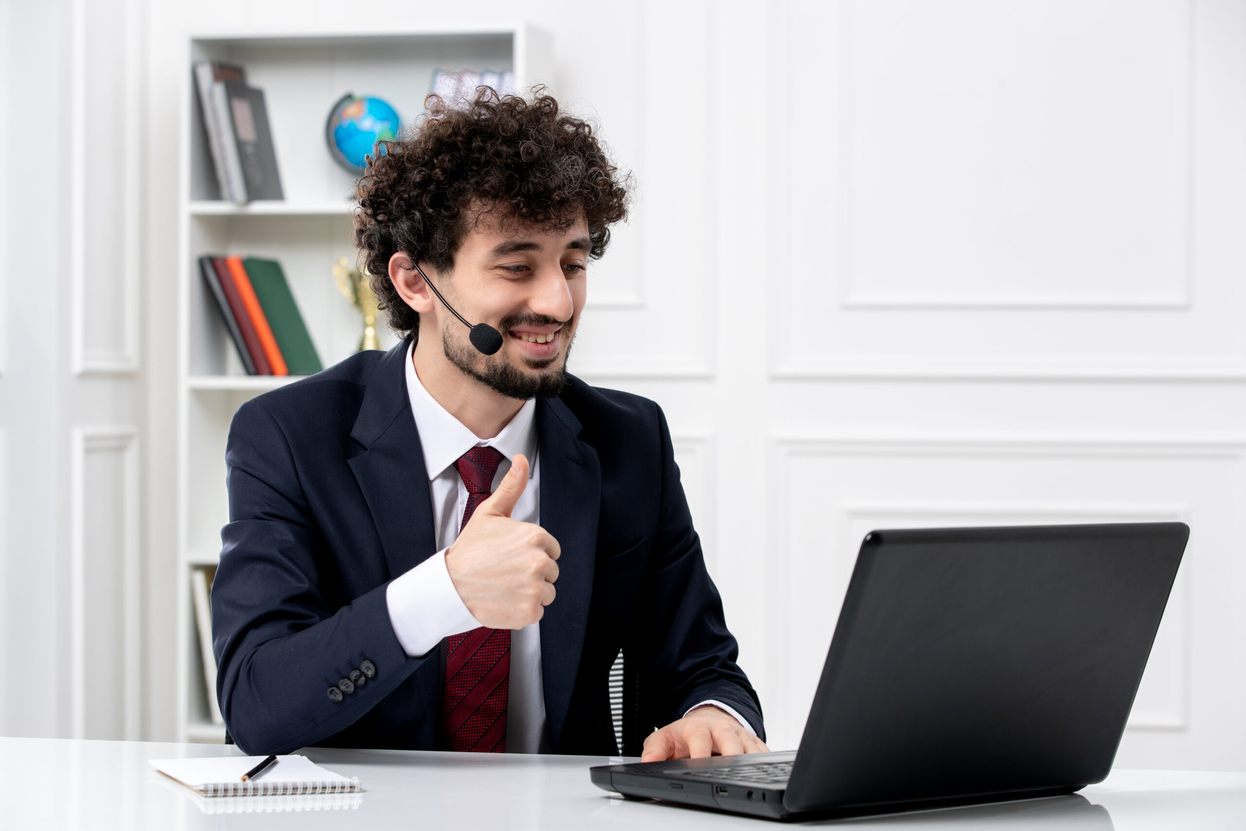 Smiling remote tech support agent in a headset assisting customers from a home office setup.