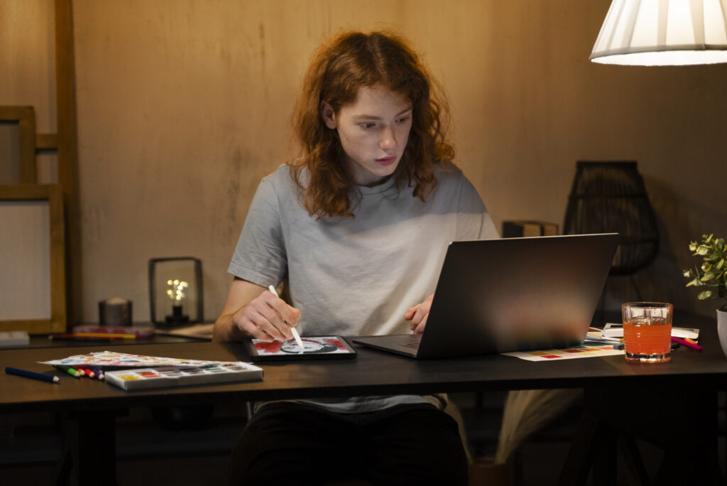 Creator designing print-on-demand products on a laptop at home