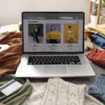 Assorted pre-loved clothing laid out on a bed – eco-friendly fashion from an online thrift shop