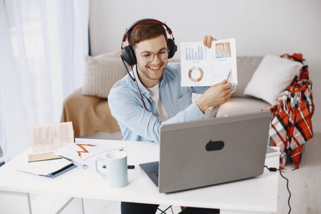 Man attending an online coaching class from home using a laptop and headset