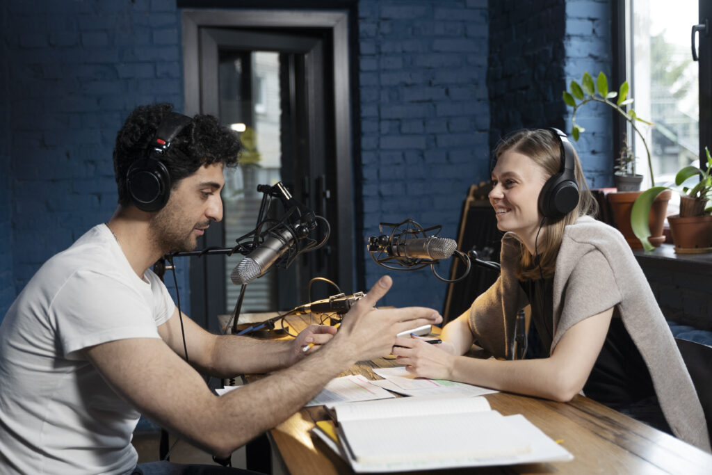 Man and woman recording voiceover dialogue for a podcast in a studio