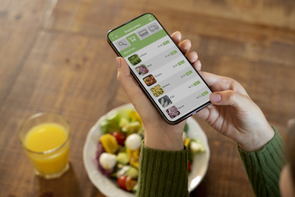 Woman ordering organic food delivery online via smartphone for California home delivery