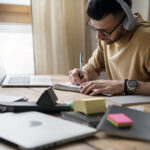 Young man writing notebook study session for Freelance Writing