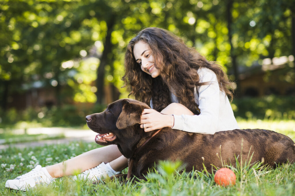 Dog parent playing with her dog safely inside a gps dog fence boundary.